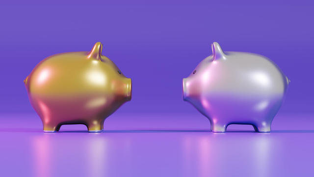 Gold and Silver Piggy Bank Facing Each Other 