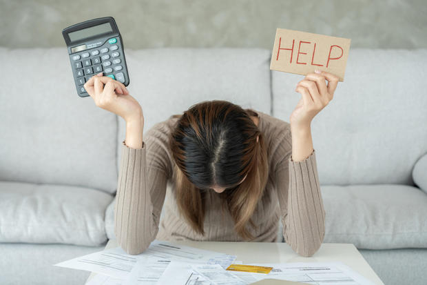 Stressed and headache asian woman with large bills or invoices no money to pay to expenses and credit card debt. shortage, Financial problems, mortgage, loan, bankruptcy, bankrupt, poor, empty wallet 