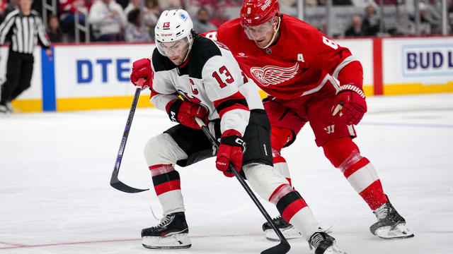 Nico Hischier #13 of the New Jersey Devils and Ben Chiarot #8 of the Detroit Red Wings battle for the puck during the third period at Little Caesars Arena on October 24, 2024 in Detroit, Michigan. 