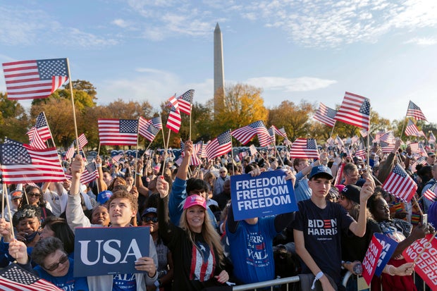 Kamala Harris supporters wave flags at campaign rally