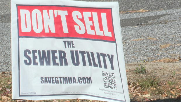 A red and white sign that says Don't sell the sewer utility 