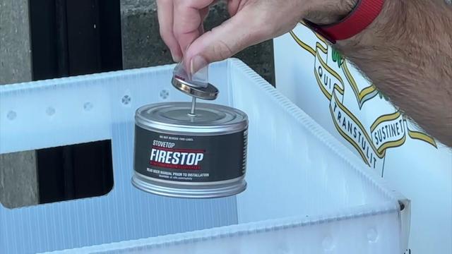 An individual holds a "firestop" canister. 