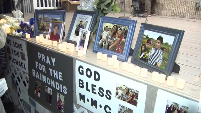 Framed photos of the Raimondi family and candles sit on the edge of a platform. 