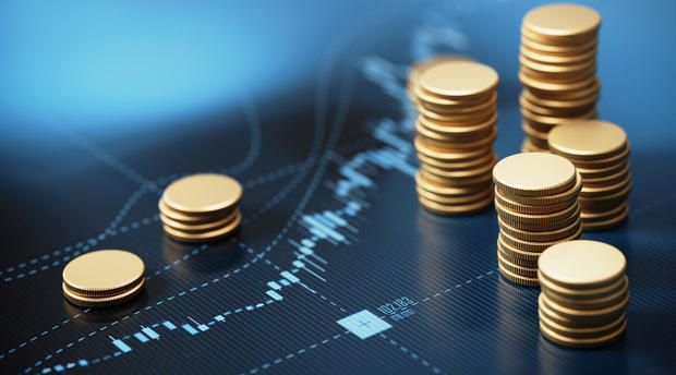 Coin Stacks Sitting On A Blue Financial Chart Background 