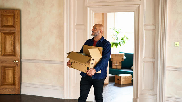 Home owner carrying boxes into new house 