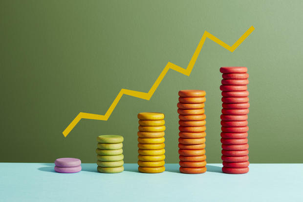 Five stacks of coloured coins with a graph line above 