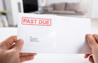 Person Holding Past Due Bill Envelope 