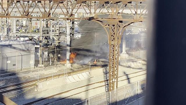 A fire burning alongside Amtrak tracks. 