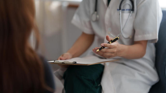 Doctor consulting patient and offer healthy food nutrition at clinic. 