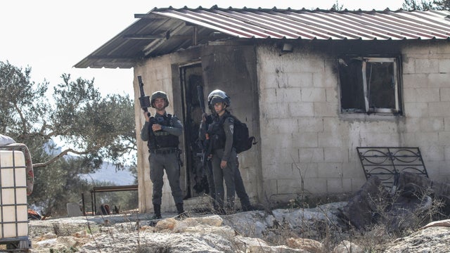 Israeli soldiers are stationed next to a house that was
