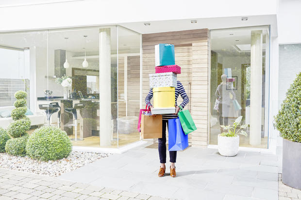 Woman hidden by her shopping bags and boxes 