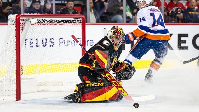 Calgary Flames Goaltender Dustin Wolf (32) stops New York Islanders Center Bo Horvat (14) during the first period of an NHL game on November 19, 2024, at the Scotiabank Saddledome in Calgary, AB.