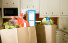 Food in grocery bags on kitchen counter. 