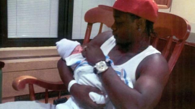 Akai Gurley holds his baby daughter 