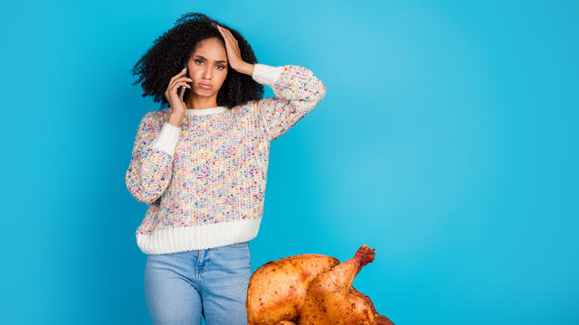 Photo portrait of attractive young woman unhappy confused talk phone celebrate thanksgiving dinner turkey isolated on blue color background 