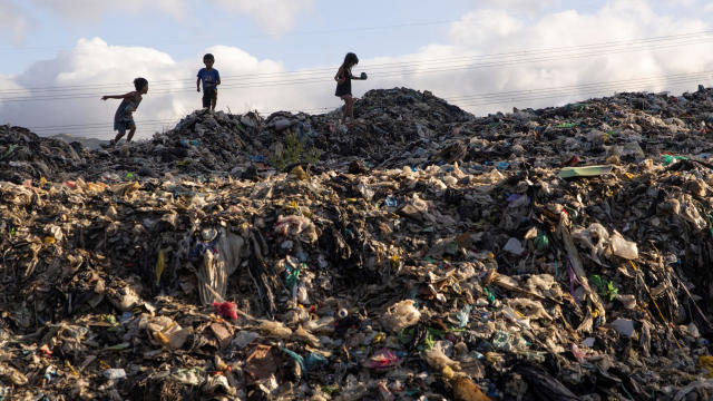 Children walk on a garbage dump filled with plastics in Rodriguez, Rizal province, Philippines, Nov. 28, 2024. 