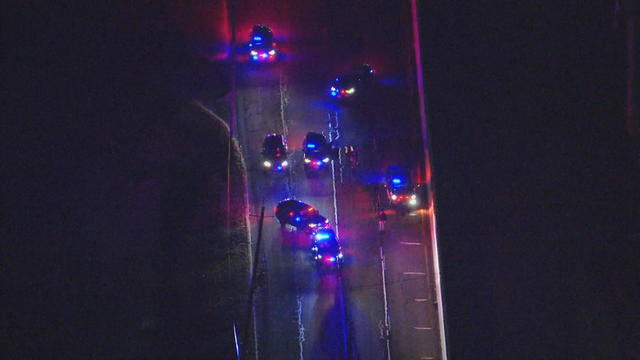 An overhead view of emergency vehicles on a highway with their lights on 