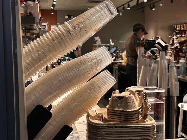 Mobile order delivery pick up window with stacks of single use plastic cups at Starbucks coffee shop, Queens, New York