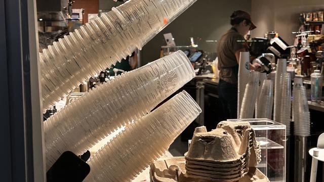 Mobile order delivery pick up window with stacks of single use plastic cups at Starbucks coffee shop, Queens, New York 