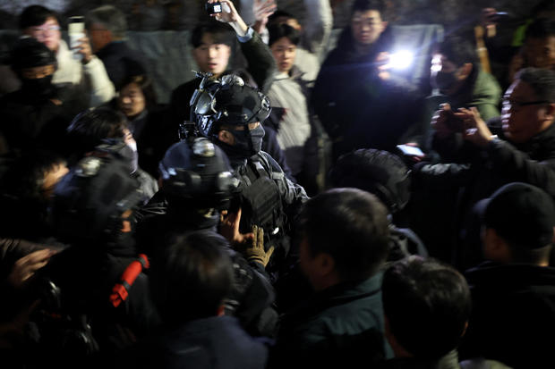 Members of the military make their way through the crowd in front of the National Assembly, after South Korean President Yoon Suk Yeol declared martial law, in Seoul, South Korea, Dec. 4, 2024. 