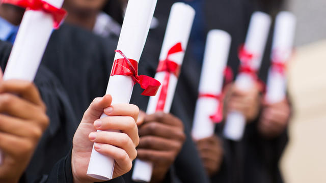 group of graduates holding diploma 