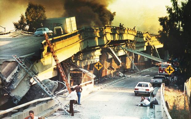 Oakland, CA October 17, 1989: Two people, lower right, comfort an injured motorist after he was pulled from the collapsed wreckage of the Cypress Freeway.The double-decked structure crumpled in the 7.0 Richter scale earthquake that shook Northern Californ 