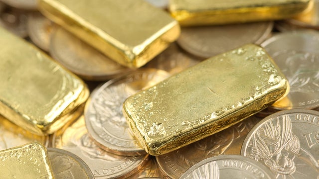 Gold bar over dollar coins 