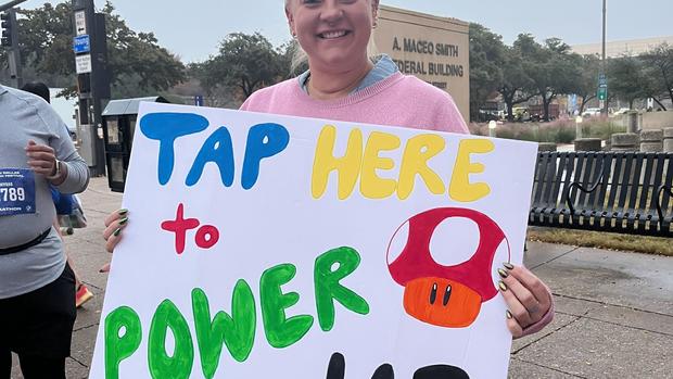 Fans cheer on runners with creative signs at the BMW Dallas Marathon Festival 