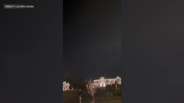 Two lights in the sky – apparent drones – can be seen over homes in New Jersey. 