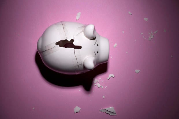 A broken piggy bank with pieces taped back together 