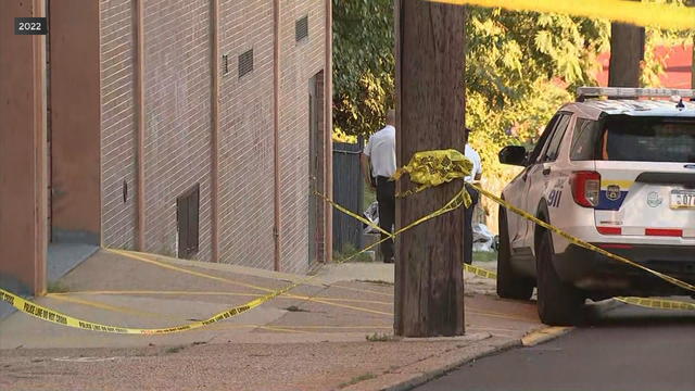 A file photo of the scene of the Roxborough shooting, a police vehicle and tape are seen on the sidewalk 