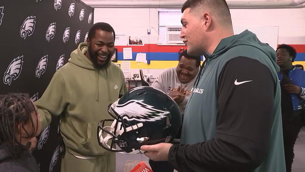 Damon Brockington smiles as a representative of the Eagles gives him an Eagles helmet 