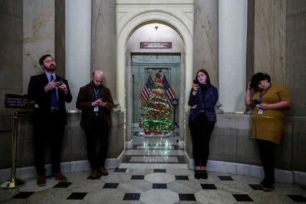 Reporters wait outside the office of Speaker of the House Mike Johnson at the U.S. Capitol on Dec. 19, 2024, in Washington, D.C. 