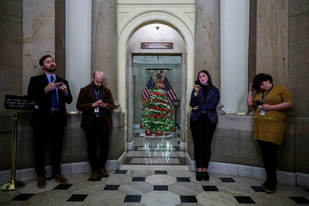 Reporters wait outside the office of Speaker of the House Mike Johnson at the U.S. Capitol on Dec. 19, 2024, in Washington, D.C.