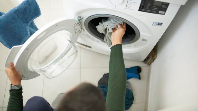 House chores - Man washing laundry with washing machine at home 