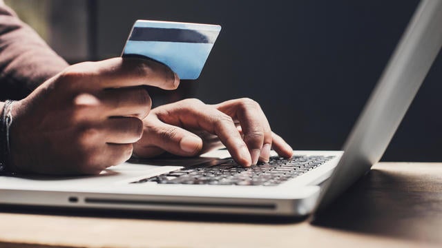 Man shopping online using laptop computer and credit card 