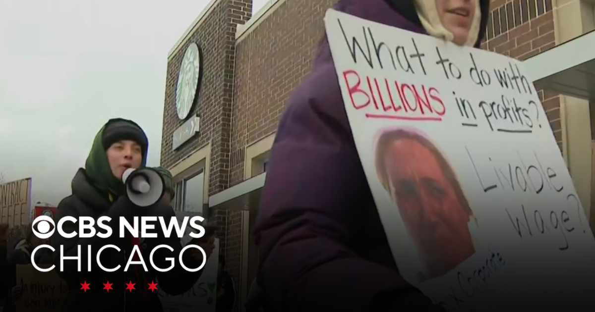 Striking Starbucks workers walk along a picket line in Chicago