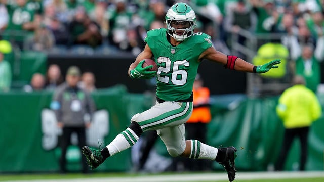 Saquon Barkley #26 of the Philadelphia Eagles runs the ball against the Dallas Cowboys, he's wearing Kelly green 