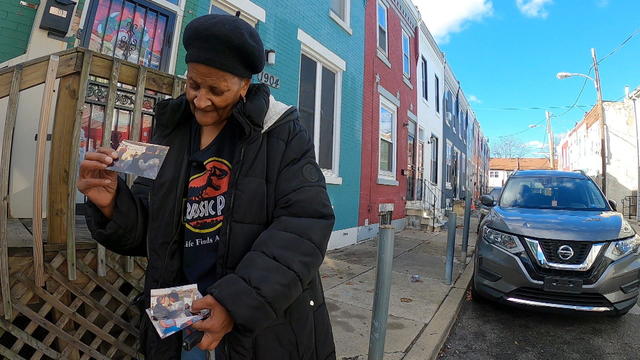 Johnson looks at a photo in front of her home 