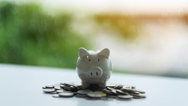 a piggy bank on pile of coins for saving money concept 