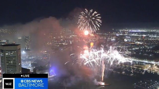 Fireworks shooting off of barge during New Years Eve celebration at Baltimore's Inner Harbor. The Constellation is seen in the middle.The location is Baltimore, Maryland, USA 