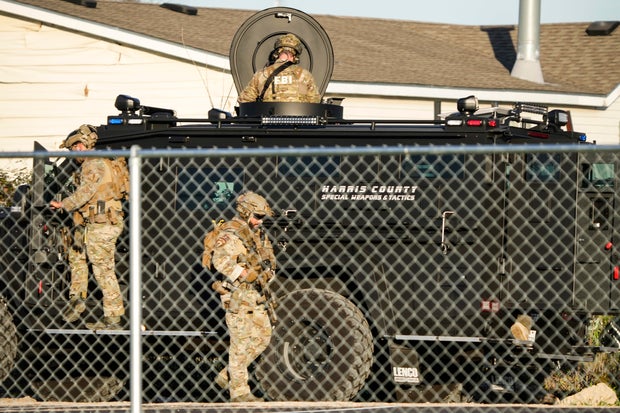 SWAT team and police investigators at suspect's home in Houston