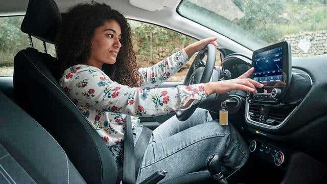 Woman using digital radio in car 