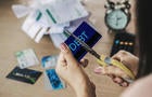 woman hand cutting credit cards by scissors with calculator and financial bills on desk 