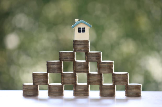 Mortgage,Model house and stack of coins money on natural green background,Business investment and real estate concept 