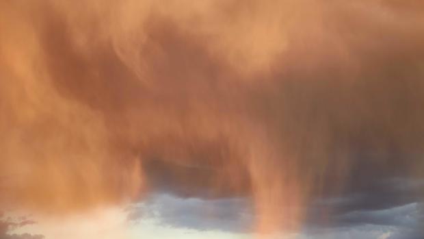 Virga, rain evaporating before reaching the ground, close-up of precipitation coming from a cloud in the evening light, variable cloudiness, selective focus, heavenly background, celestial landscape. 