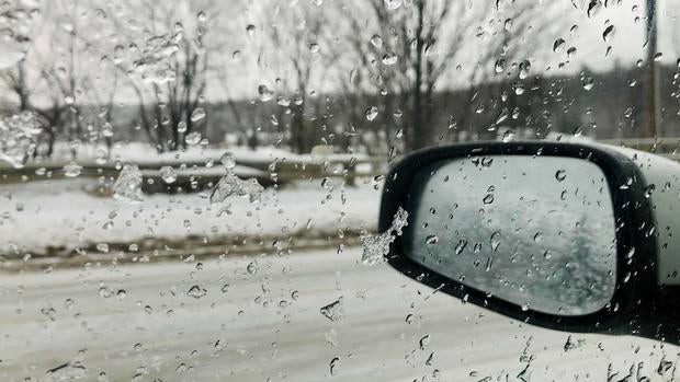 Looking out driver's side window of car during a freezing rain storm in New Hampshire USA 