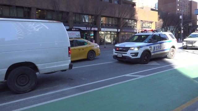 An NYPD vehicle parked behind a white van in Manhattan. 