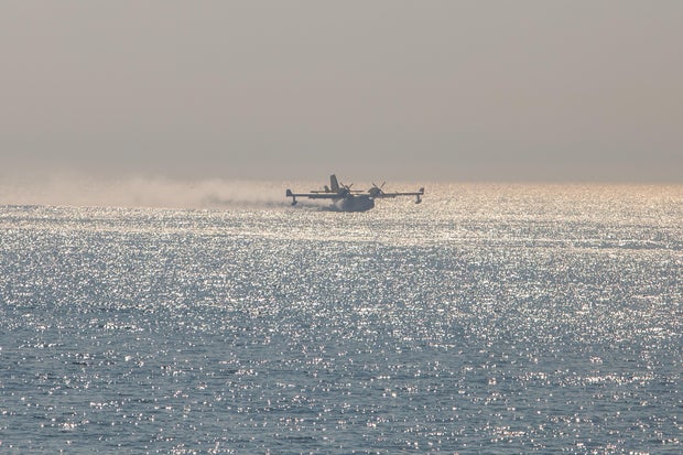 An airtanker gets water from the ocean to fight the Palisades Fire, Jan. 9, 2025.