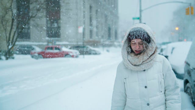 Teenager girl walks under snowfall at the street in Manhattan 